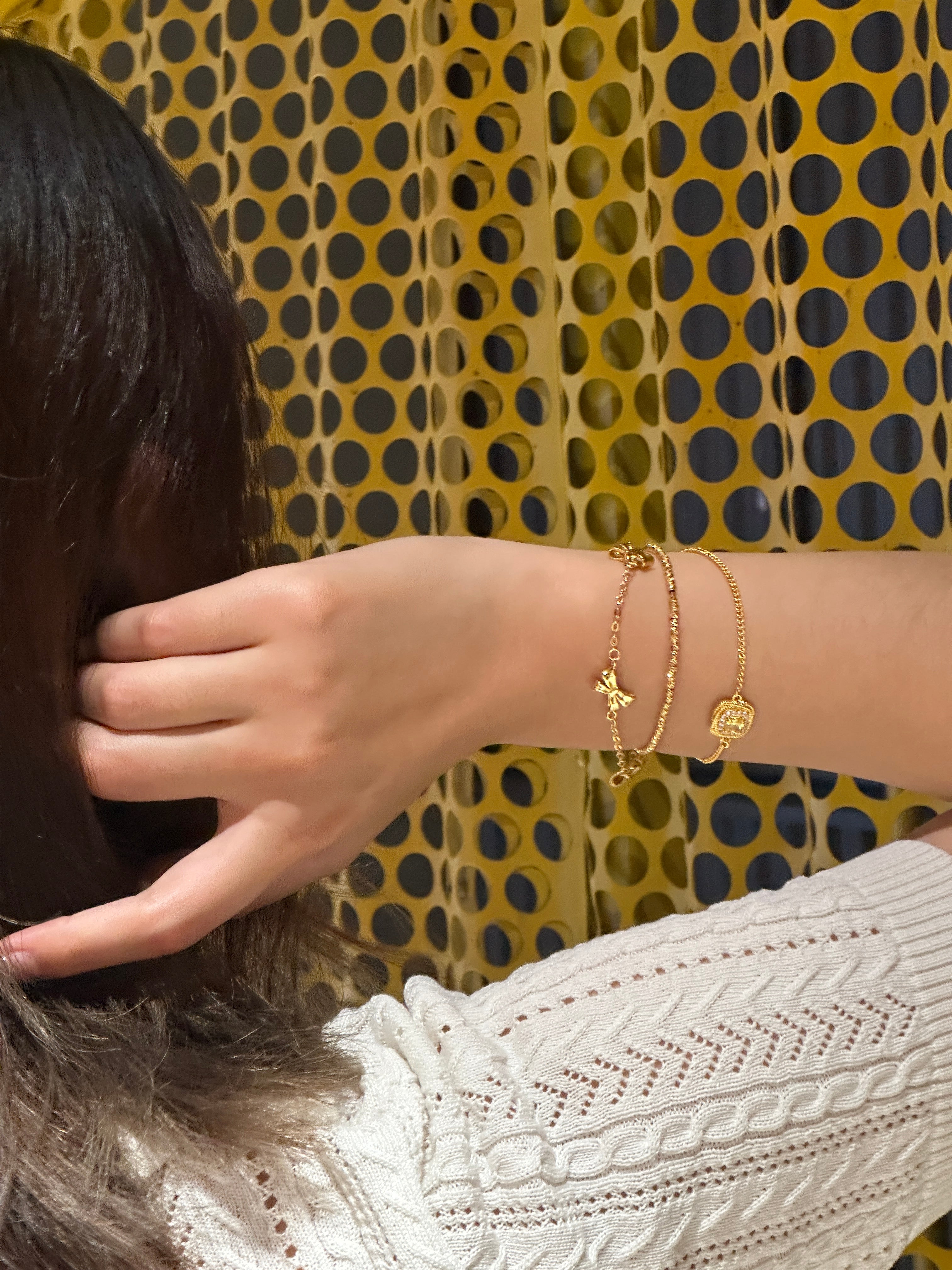 On-wrist shot: Drifting Twilight and Golden Bow minimalist gold bracelets stacked with a chain bracelet Gilded Ripple, 18K gold plated, adjustable