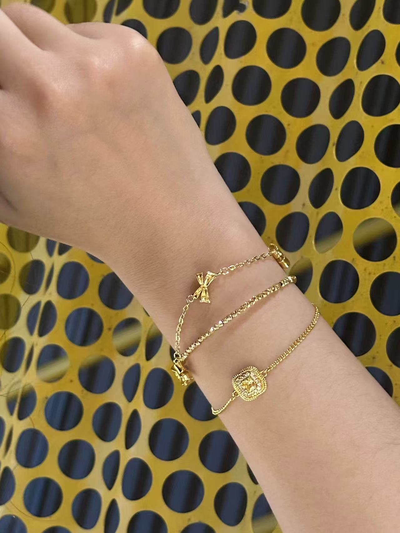 Gilded Ripple minimalist 18K gold plated bracelet stacked with chain and charm bracelets on wrist, nickel safe