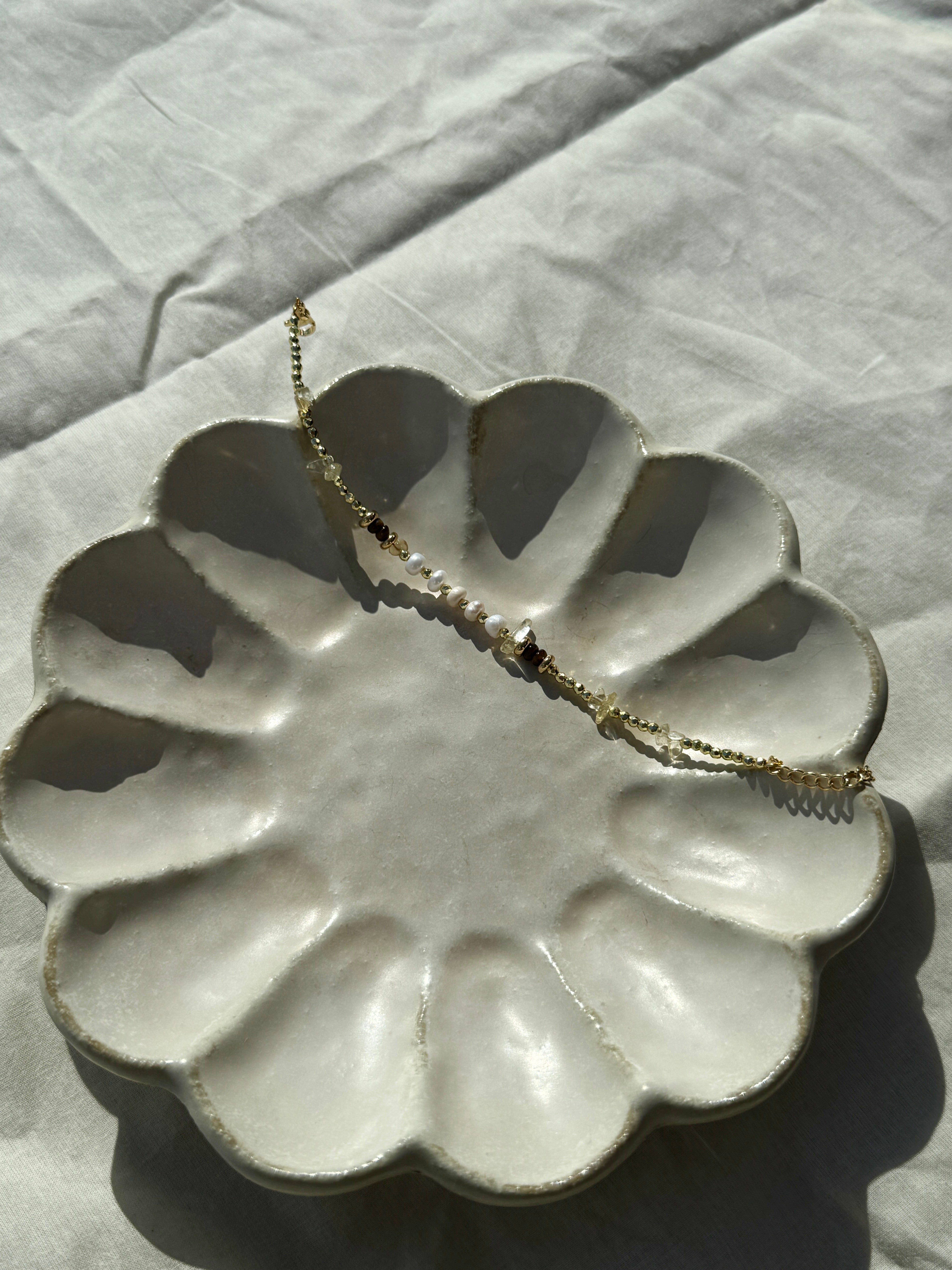 Minimalist crystal bracelet stacked with a chain bracelet, champagne beads
