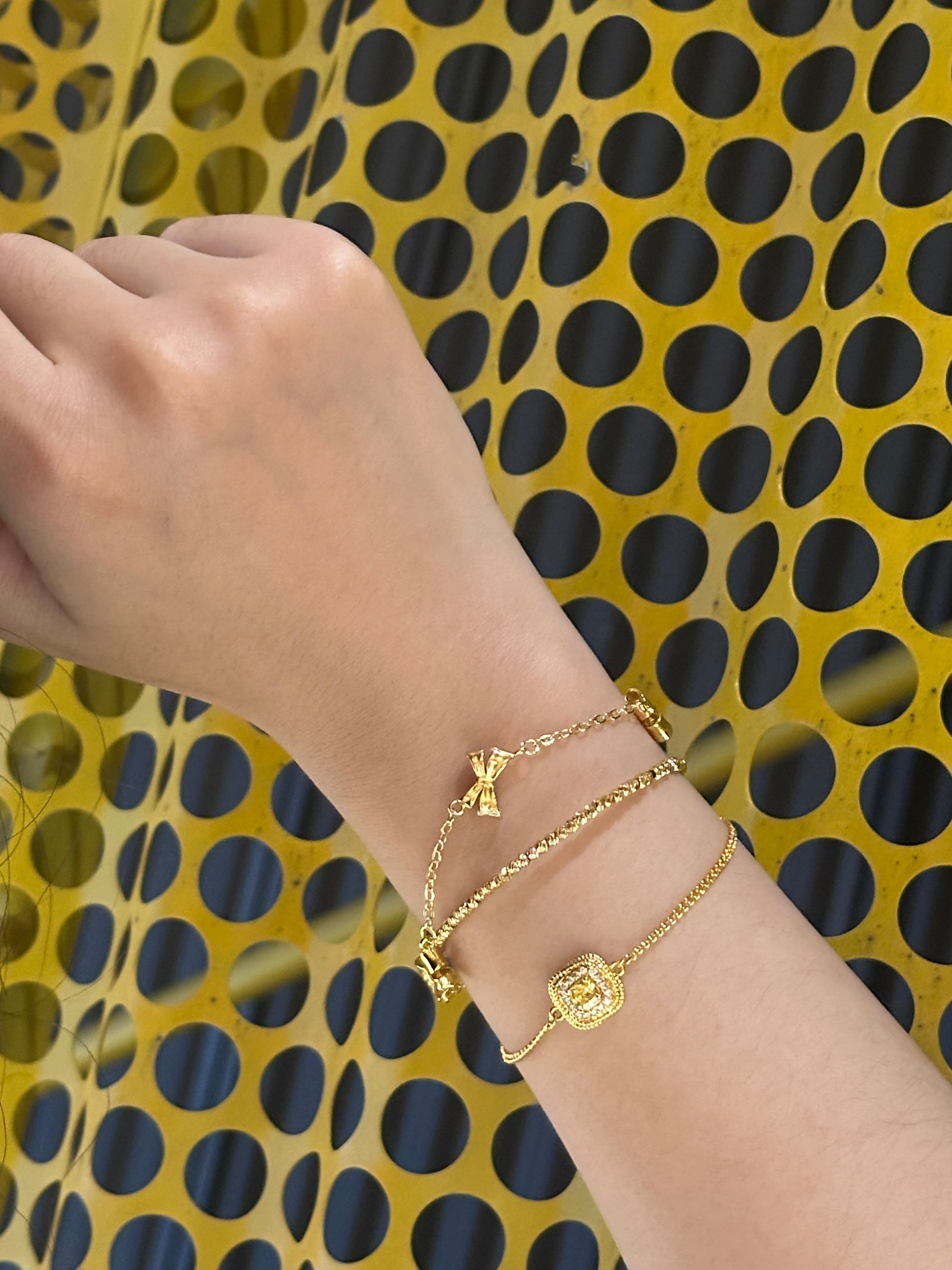On-wrist shot: Drifting Twilight and Golden Bow minimalist gold bracelets stacked with a chain bracelet Gilded Ripple, 18K gold plated, adjustable